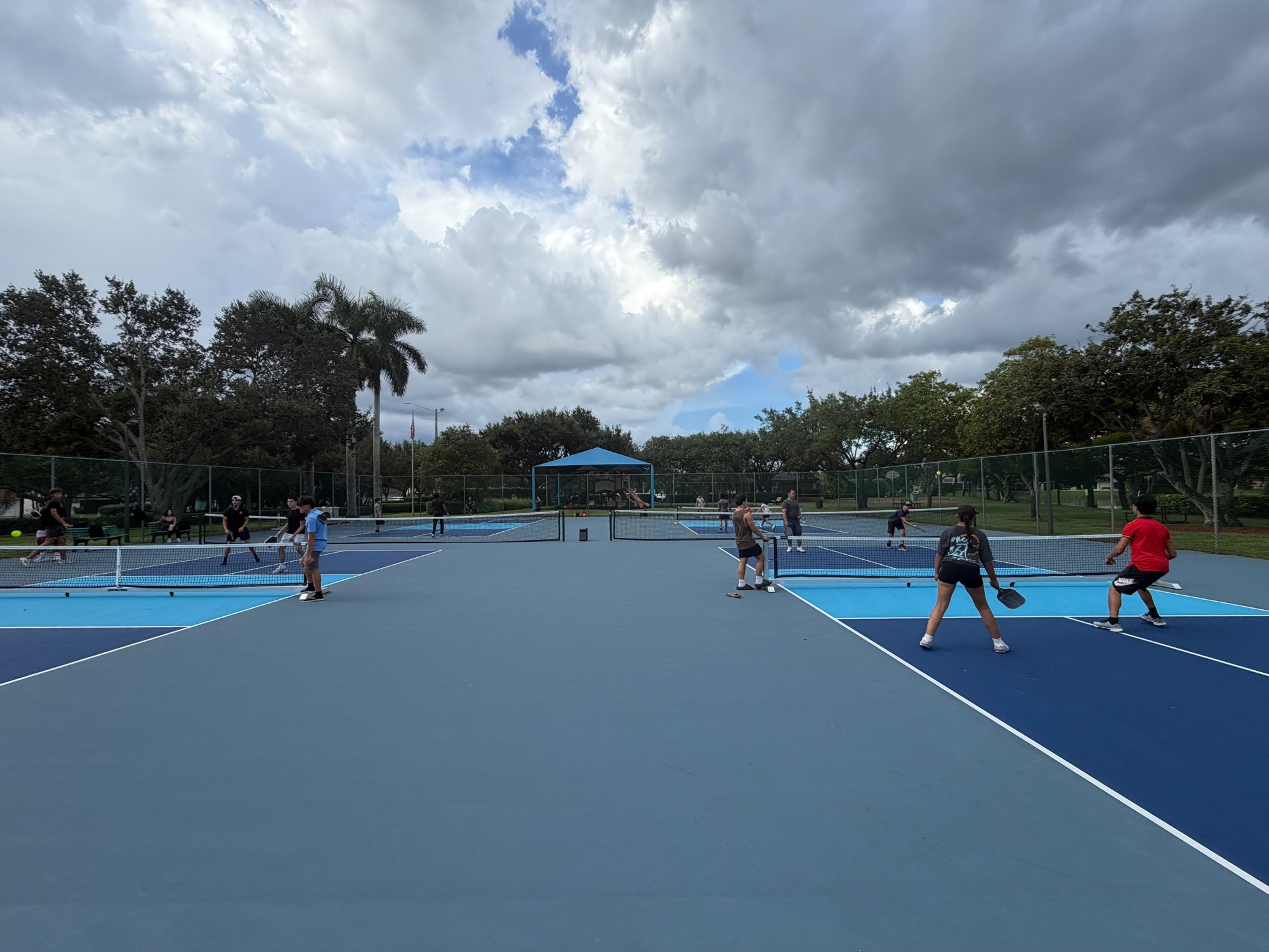 EnginX members playing pickleball on outdoor courts under a cloudy sky
